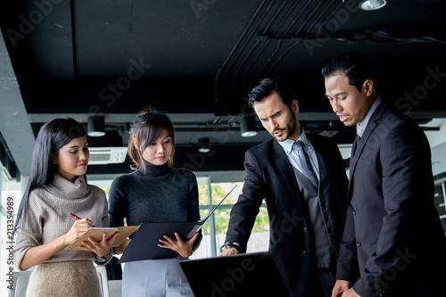 Group of business discussing ducuments and ideas at meeting. photo