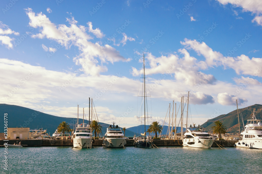 Beautiful landscape with blue sky, white clouds and line of yachts. Montenegro, Tivat, view of yacht marina of Porto Montenegro