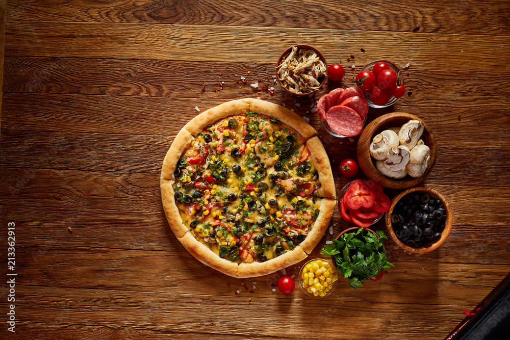 Pizza still life. Part of freshly baked pizza and its components arranged on wooden background. Pizza still life. Part of freshly baked pizza and its components arranged on wooden background.