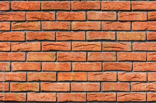 Red brick wall. Decorative brick with artificial defects and cracks.
