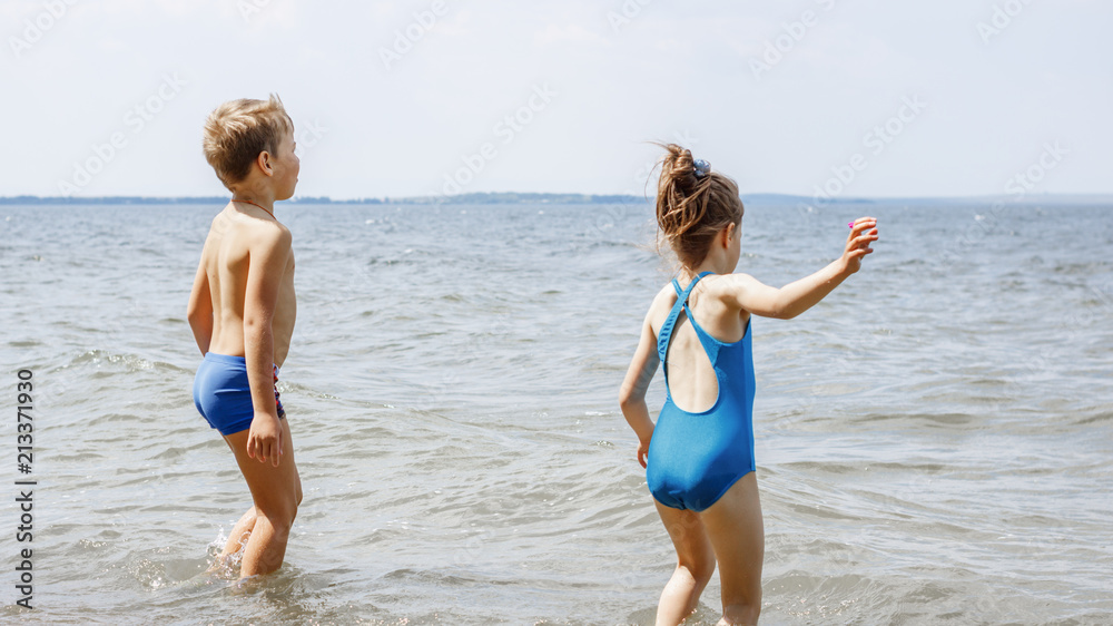 Naklejka premium Children have fun playing on the seashore