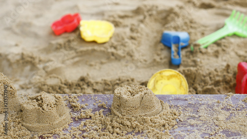 children's toys are scattered in the sandbox. Blade, rake, pail for building a sand tower