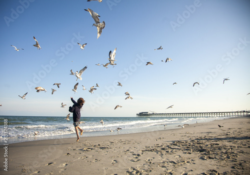 Child Feeding Seagulls at Beach