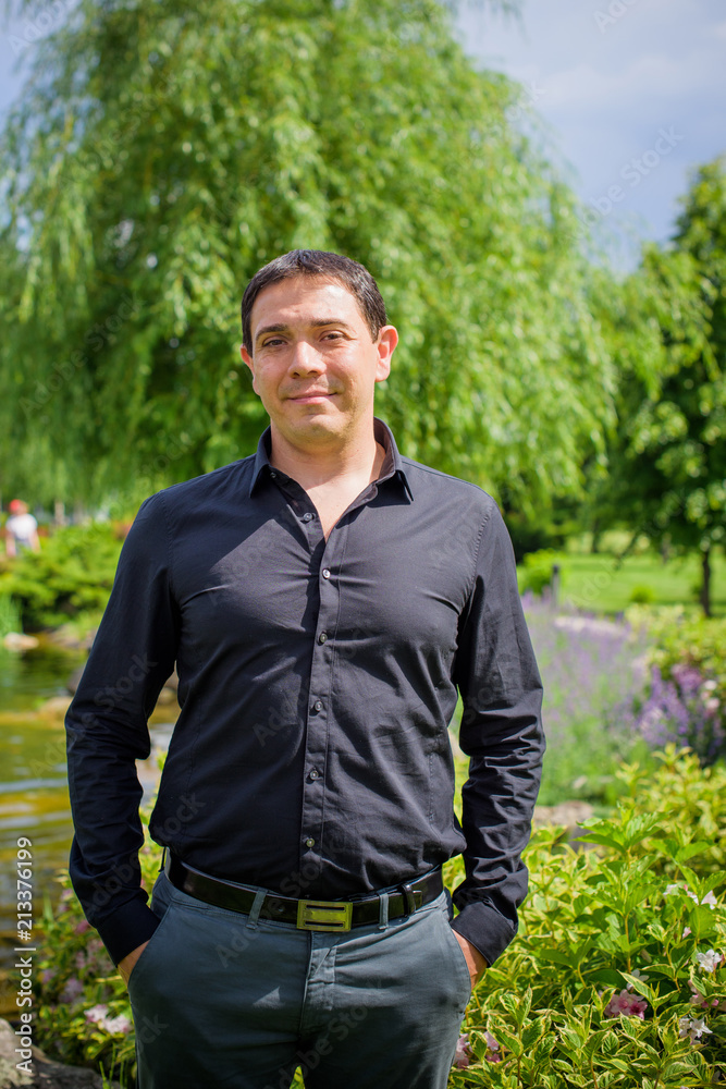 Middle age arabic smiling man in black shirt at park with good mood Middle age arabic smiling man in black shirt at park with good mood