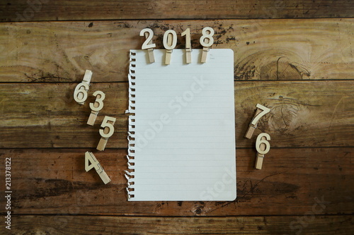 Cloth pin with number of year 2018 and a piece of blank paper. Copy space for text or logo.