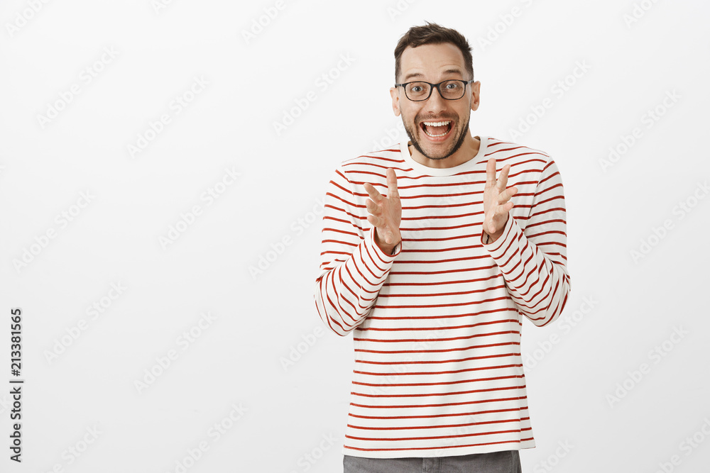 Portrait of overwhelmed cute european guy with bristle in black trendy glasses, shaking palms while explaining something awesome, being astonished with great news, retelling it to friend Portrait of overwhelmed cute european guy with bristle in black trendy glasses, shaking palms while explaining something awesome, being astonished with great news, retelling it to friend
