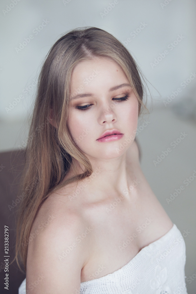 young girl with bare shoulders in light colors