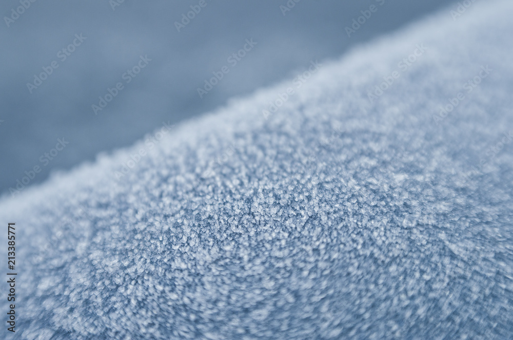 Frozen water, ice crystals on blue surface