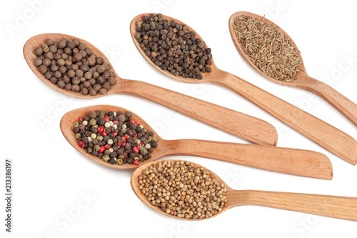 Spices in wooden spoons isolated on white