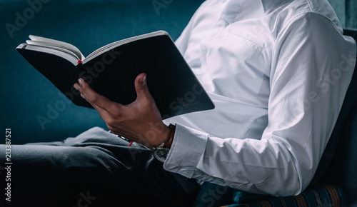 Businessman reading a book on the office for cooperation and partner concept and enjoy learning, He was happy to relax on holiday.