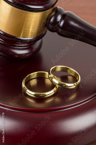 Wooden judge gavel and golden rings divorce concept