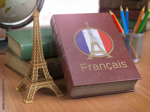 Learn and studiyng French concept. Book with  French flag and Eiffel tower on the table. photo