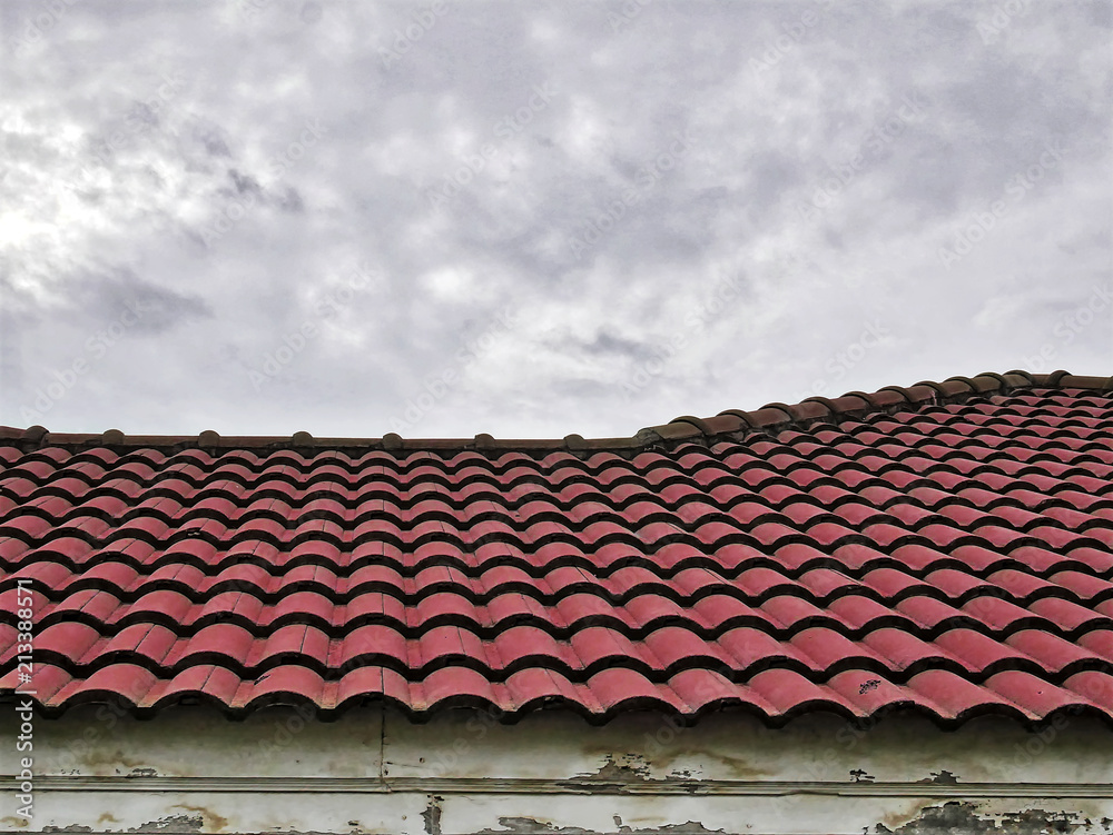 Old Red Tiled Roof Against Cloudy Sky