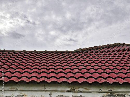 Old Red Tiled Roof Against Cloudy Sky