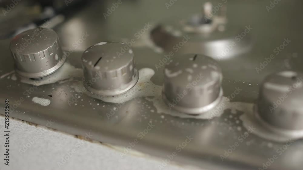 woman in gloves cleans a gas stove. woman in gloves cleans a gas stove.