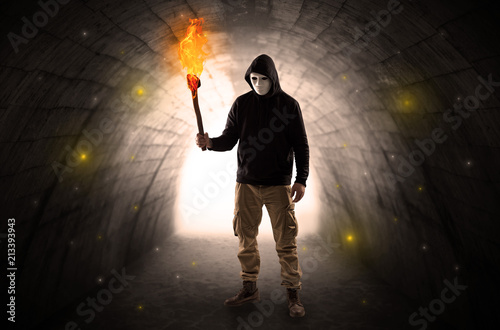 Ugly man with burning flambeau walking in a dark tunnel © ra2 studio
