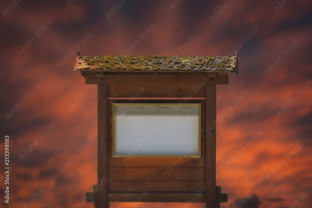 Free space for an inscription or image on an old wooden billboard against the backdrop of the setting sun.