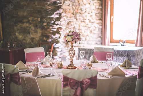 wedding table with exclusive floral arrangement prepared for reception, wedding or event centerpiece in rose gold colour