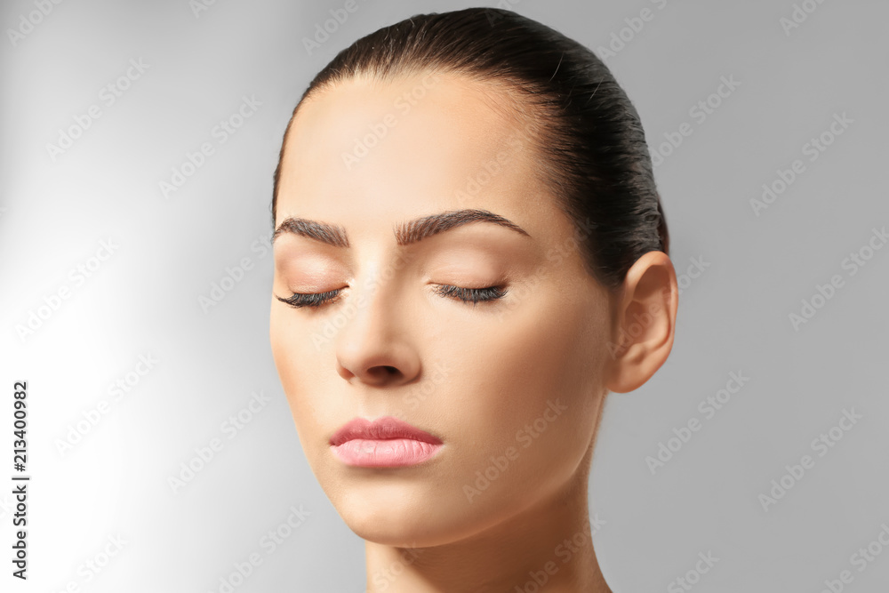 Young woman with beautiful eyebrows on light background Young woman with beautiful eyebrows on light background