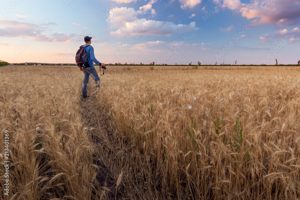 photographer while working search for a story / evening landscape man on the field photographer while working search for a story / evening landscape man on the field