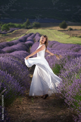 Happy young woman in a white dress in a lavender field