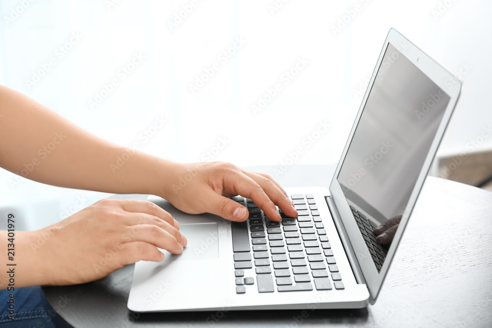 Young man using laptop at table indoors Young man using laptop at table indoors