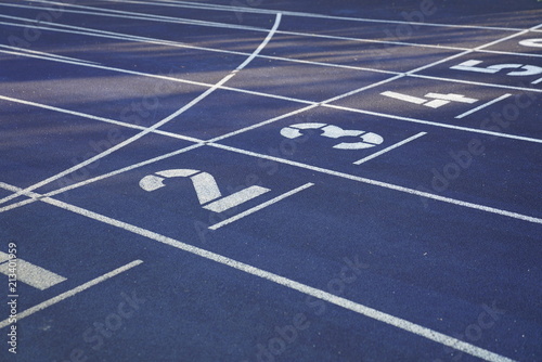 Fototapeta Naklejka Na Ścianę i Meble -  Start positions of a blue outdoor stadium running track with white dividing lines