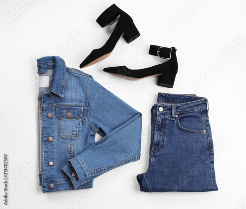 Flat lay composition with jeans, denim jacket and shoes on white background