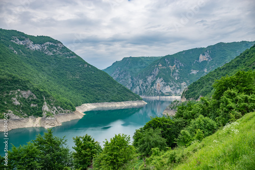 An unusual mountain lake with turquoise water is located in a canyon among the high mountains. © Sergej Ljashenko