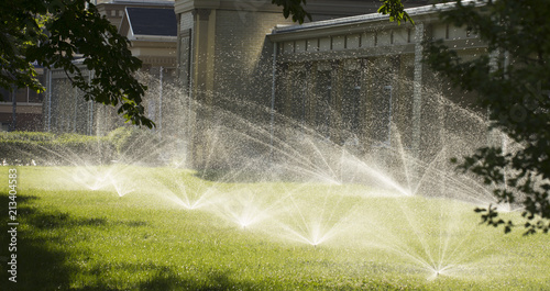 automatic sprinkler system watering the lawn on a background of green grass photo