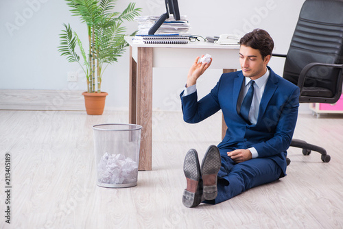 Young handsome businessman employee working in office in paperwo photo