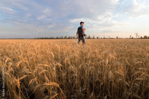 photographer while working search for a story / evening landscape man on the field