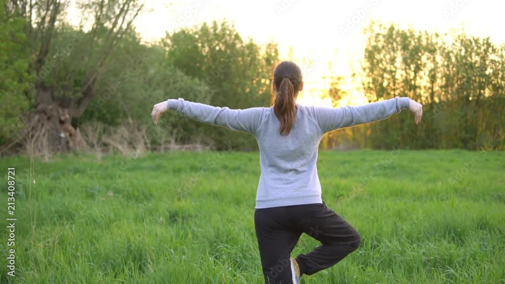 Young woman doing exercises in the field at sunrise. Young woman doing exercises in the field at sunrise.