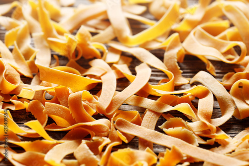 Orange noodles and pasta on a wood background