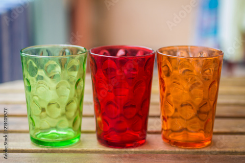 three multi-colored glasses against blurred background