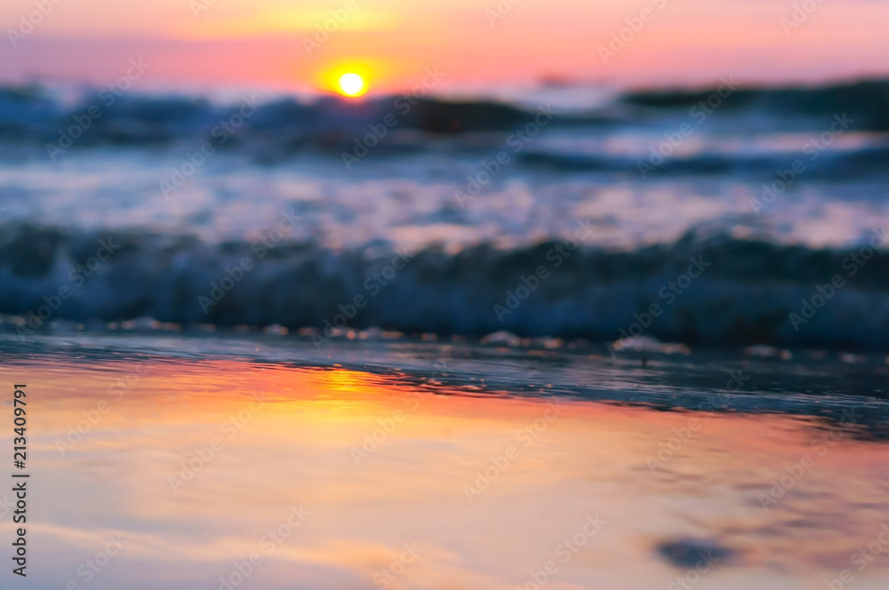 Sunset over the sea. Reflection of sunlight in the sea waves. Red sky in the rays of the sunset.