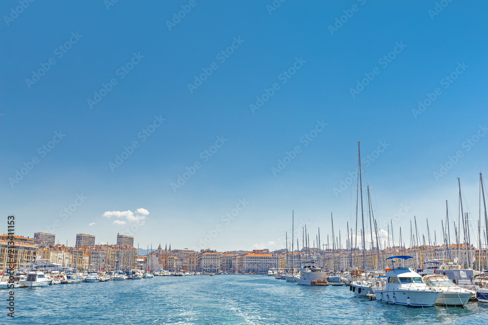 Marseille, France, breathtaking seascape and port. View from sea. Port Marseille, yachts in marina and cityscape on background. Plenty of copy space as blue sky background for advertisement script. 