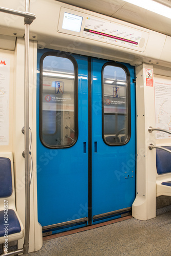 View of bright empty interior of modern subway train car. Contemporary inside space of the underground railway carriage with no one inside, empty seats.