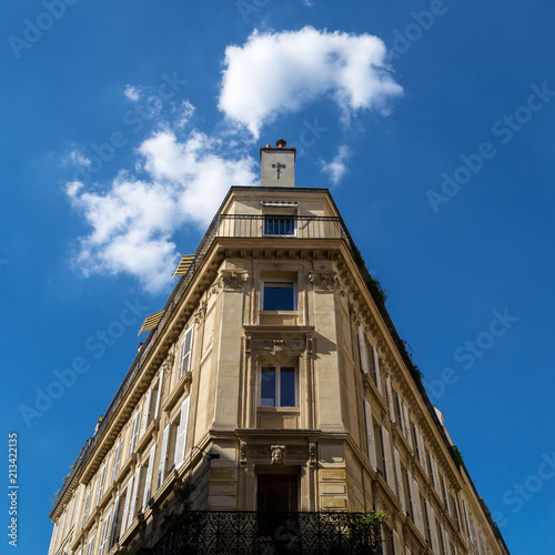 Immeuble parisien sous ciel ensoleillé + nuages