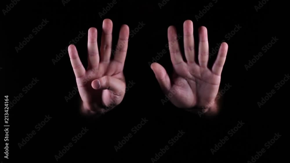 Hand gestures coming out of the dark into the light. The number nine. Hand gestures coming out of the dark into the light. The number nine.