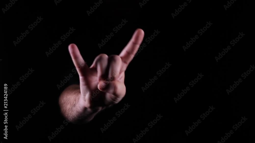 Hand Gestures coming out of the dark into the light. Devil Horns. Hand Gestures coming out of the dark into the light. Devil Horns.