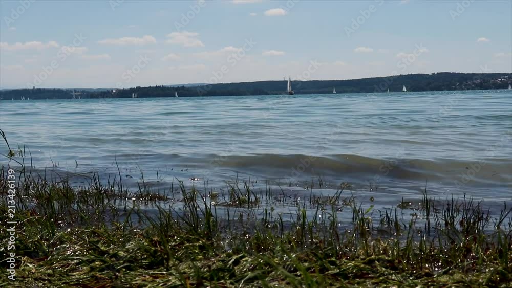 A Timelapse of little waves hitting the shore and boats floating in the lake. A Timelapse of little waves hitting the shore and boats floating in the lake.