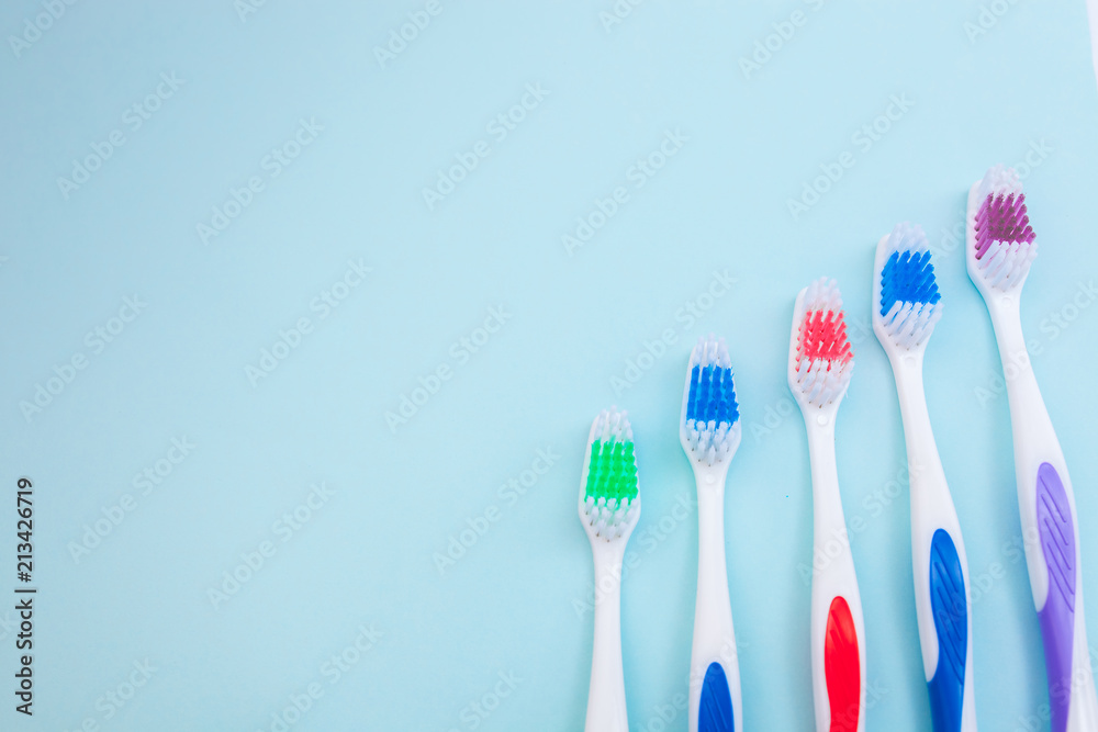 Toothbrushes on light blue background, close up different kinds of Toothbrushes, new not used, isolated for text insertion Toothbrushes on light blue background, close up different kinds of Toothbrushes, new not used, isolated for text insertion