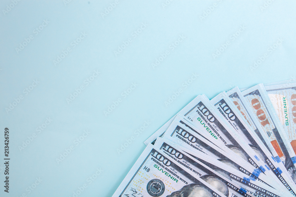 Many bills of 100 dollars, American banknote, blue background with money cash currency close-up, the President's face Many bills of 100 dollars, American banknote, blue background with money cash currency close-up, the President's face