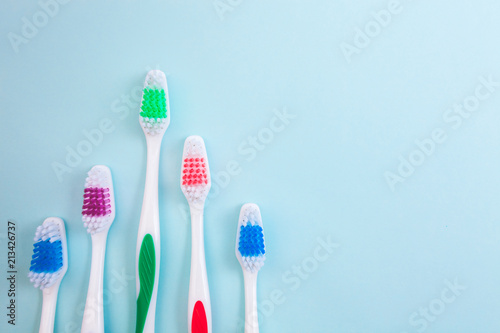 Toothbrushes on light blue background  close up different kinds of Toothbrushes  new not used  isolated for text insertion  one of the best  old and new brushes