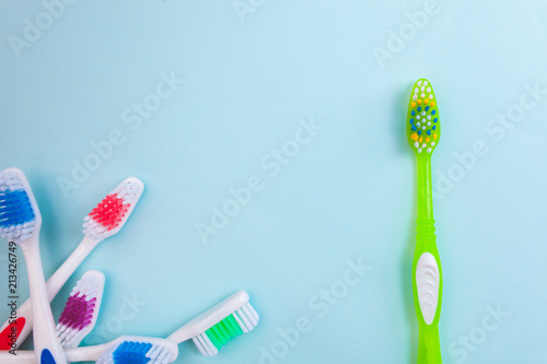 Toothbrushes on light blue background  close up different kinds of Toothbrushes  new not used  isolated for text insertion  one of the best  old and new brushes