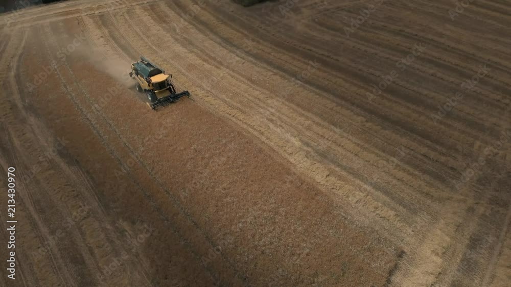 A combine harvester at sunset, shot in 4K by a professionnal drone and ...