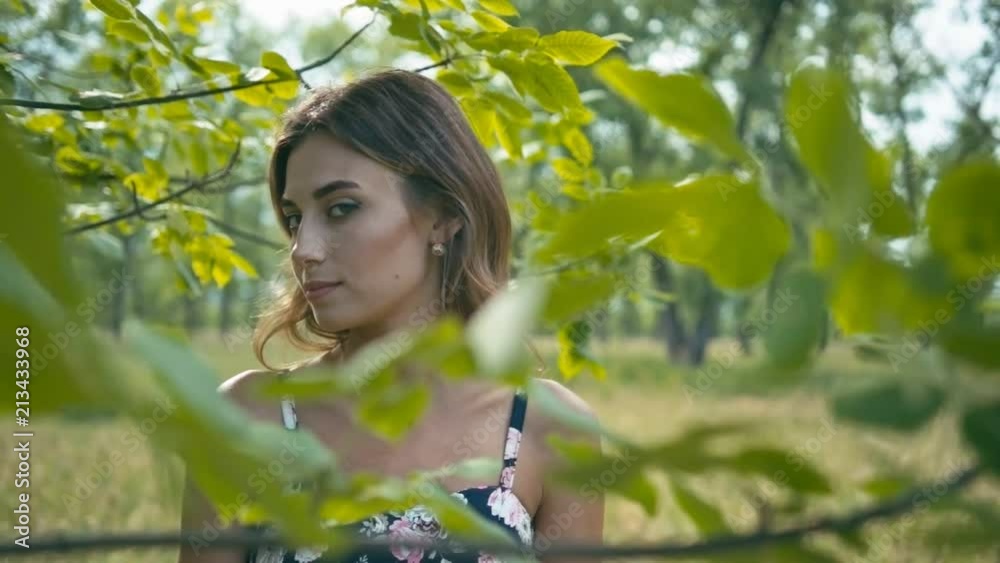Young woman in green leaves, closeup, shallow depth of field, slow motion Young woman in green leaves, closeup, shallow depth of field, slow motion