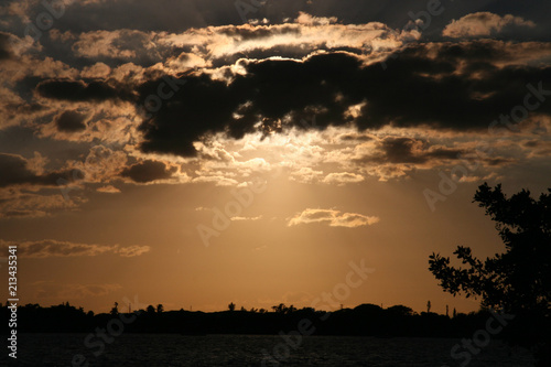 Sky with sun rays through the dark clouds over the lake