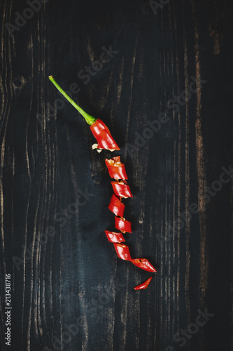 Red hot chilli pepper on black wood, top view